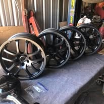 Black powder coated alloy wheels on a table