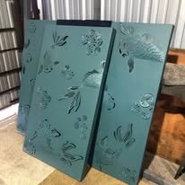 Teal laser-cut decorative metal panels with koi fish and floral cutouts
